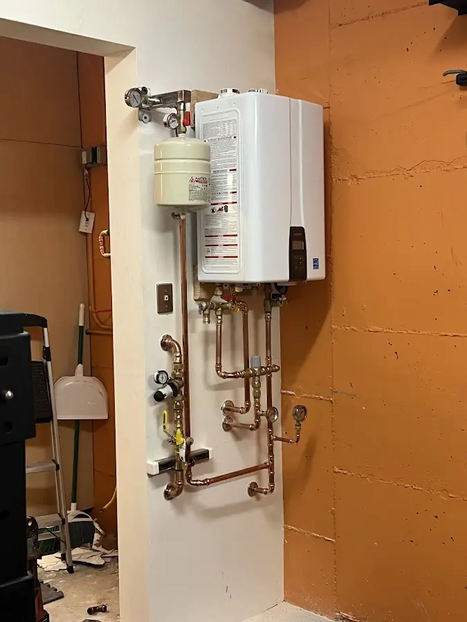 Plumbing technician inspecting water heater connections in Bright